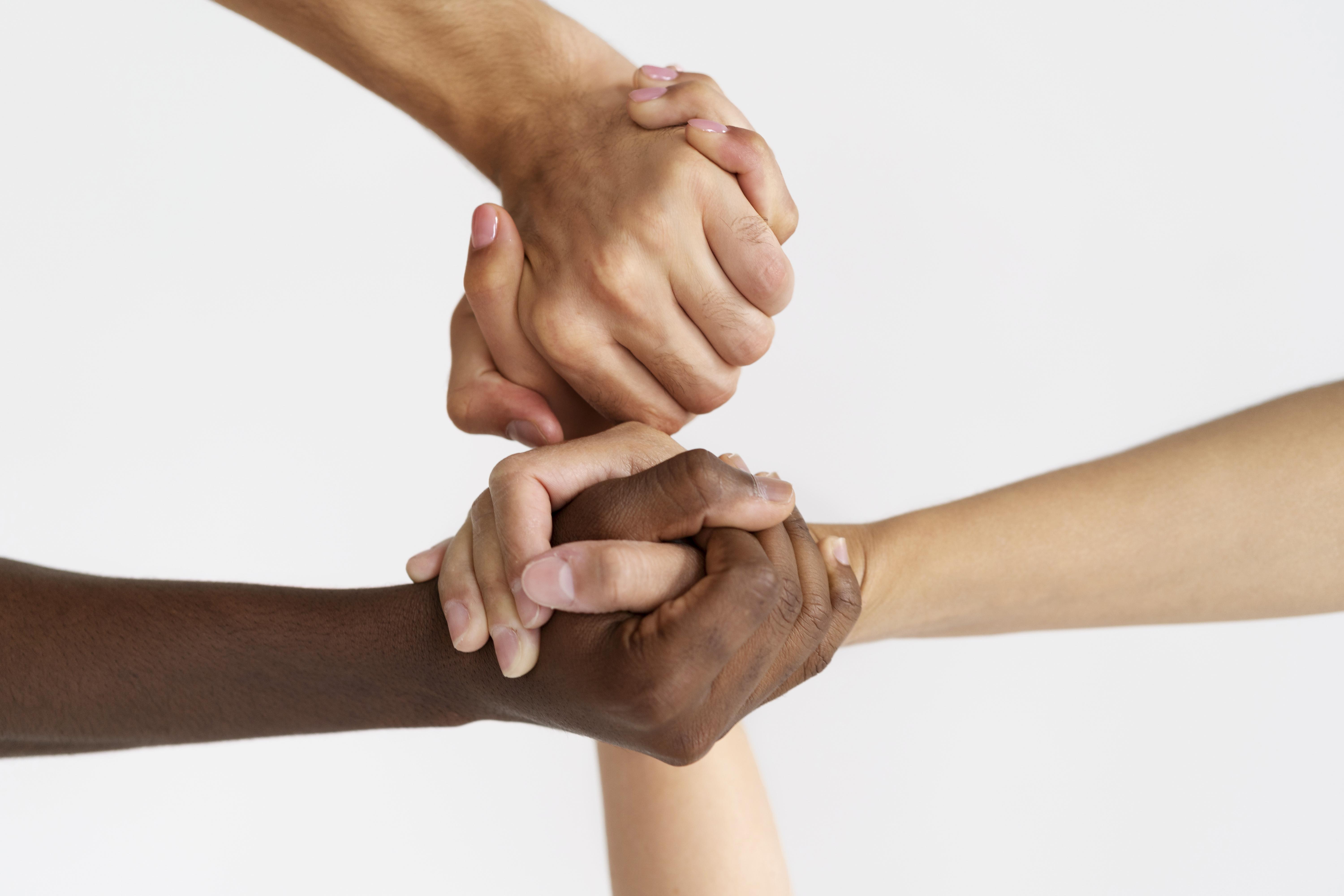 Mãos de várias pessoas unidas em colaboração